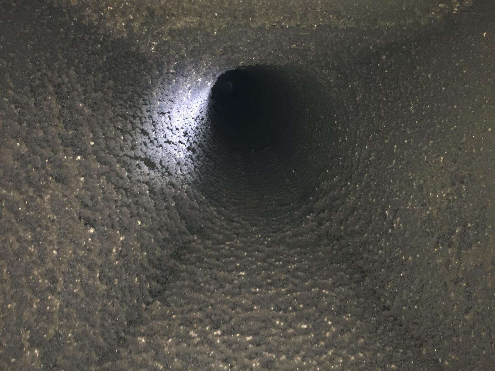 Chimney interior showing circular flue opening with light — HETAS chimney sweep, Norfolk