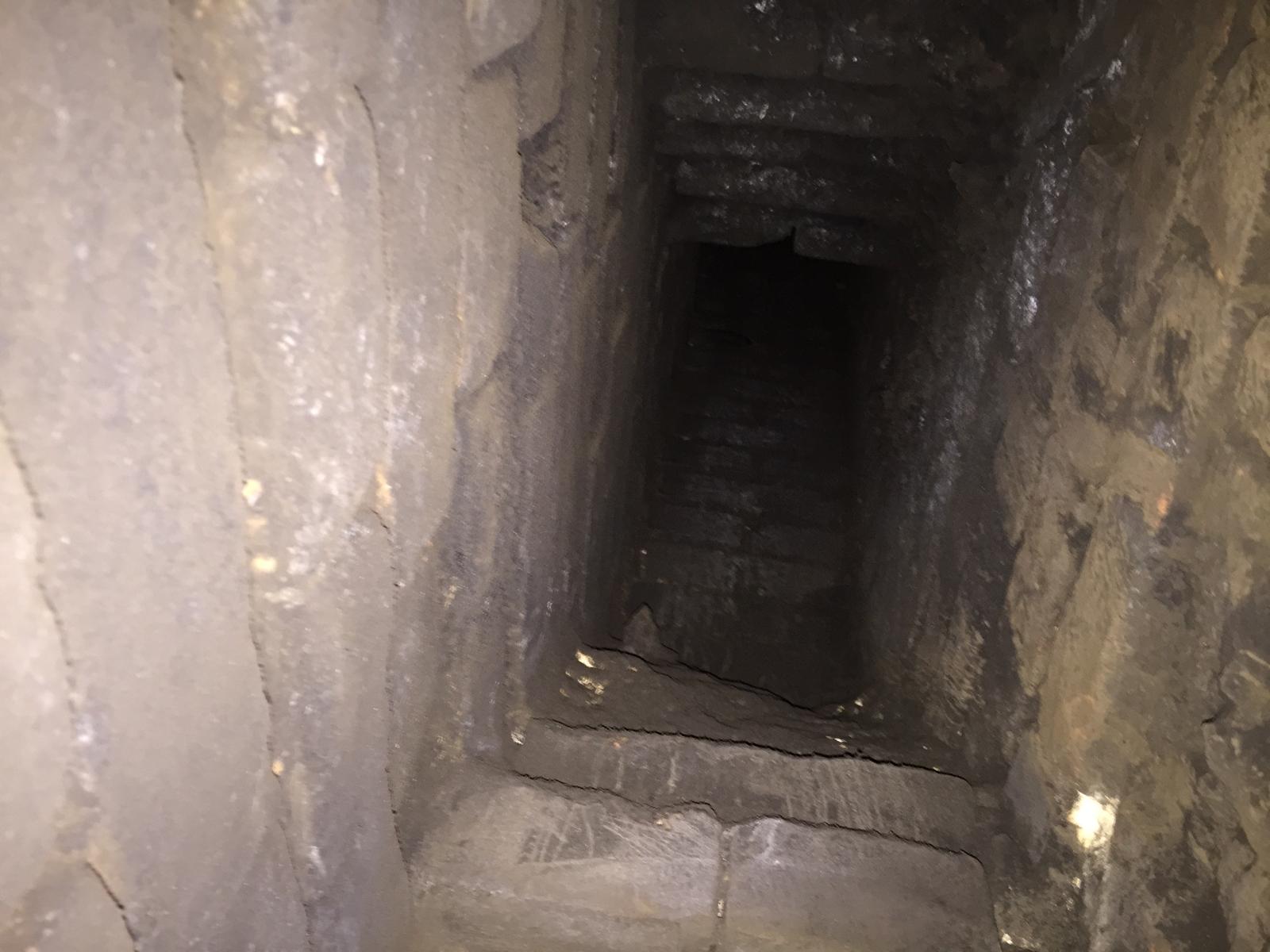 Black wood burning stove on slate hearth with twin wall flue through ceiling — Norfolk